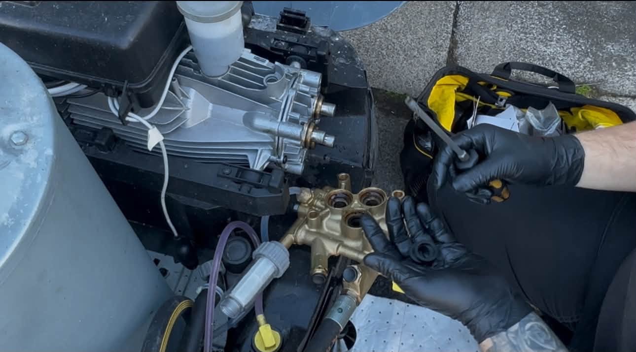 Technician servicing a pressure washer pump